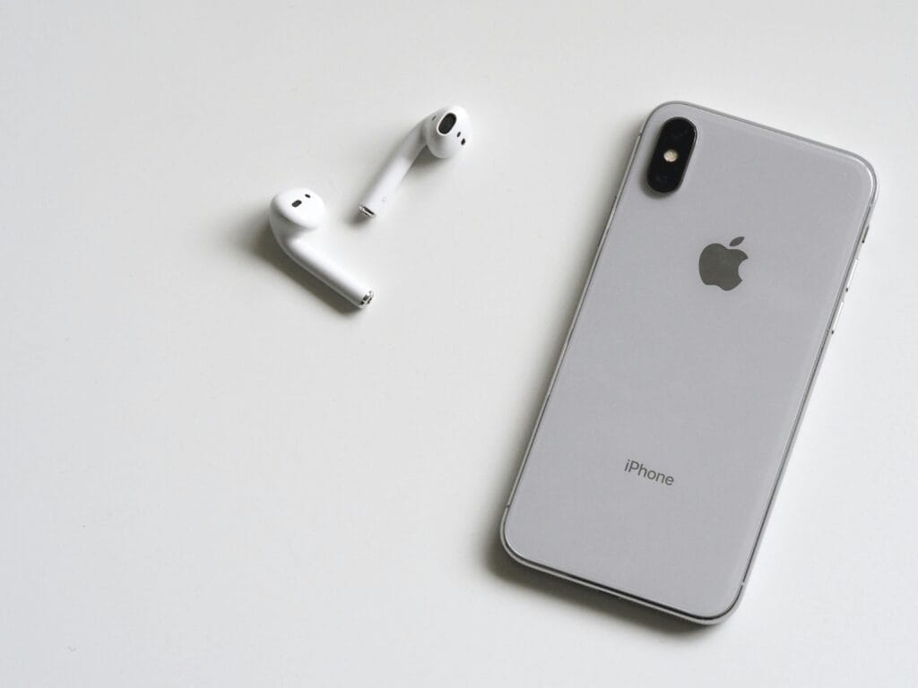pexels-photo-788946-788946 Close-up of a silver iPhone and wireless AirPods on a sleek white background.